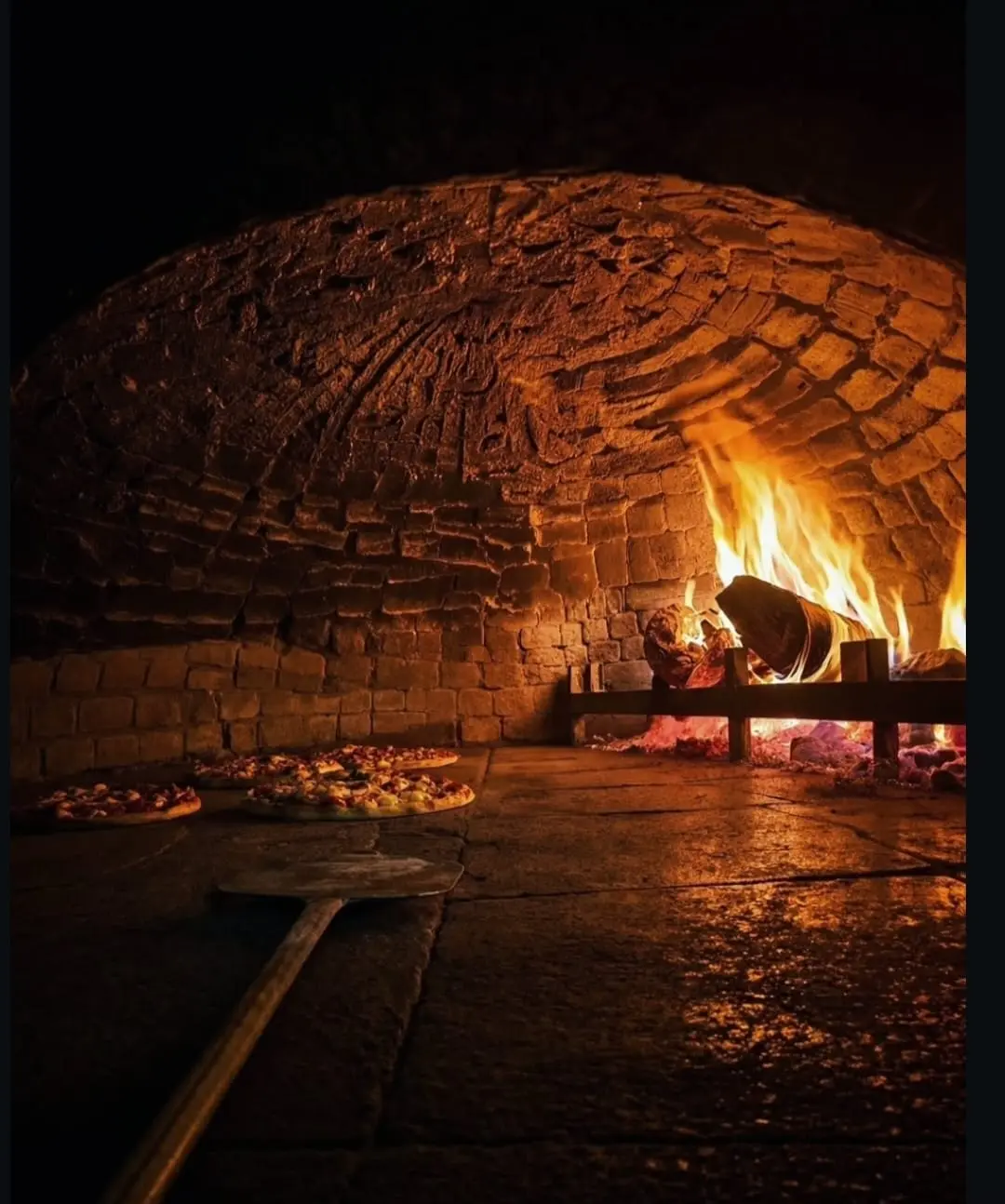 Pizzas baking in Olivo's wood-fired stone oven